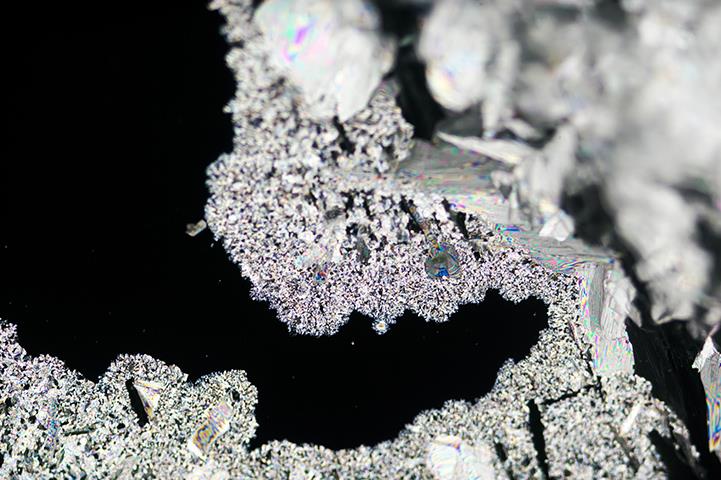 urea crystallization on black background under polarized light