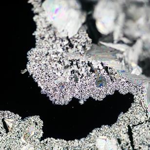 urea crystallization on black background under polarized light